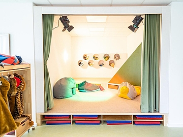 Foto vom Raum im Fröbel-Kindergarten Wakhegge mit einer Bühne und Kostümen zum Verkleiden